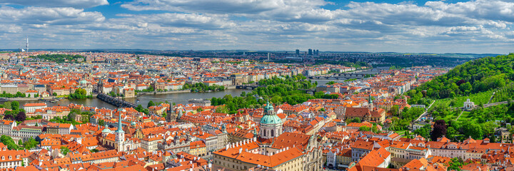 Panorama of Prague city. Aerial panoramic view of Prague Old Town historical centre, Charles Bridge Karluv Most across Vltava river and Mala Strana Town with red tiled roof buildings, Czech Republic