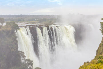 Fototapeta na wymiar Victoria Falls, a waterfall in southern Africa at the Zambezi River at the border between Zambia and Zimbabwe. Milky water