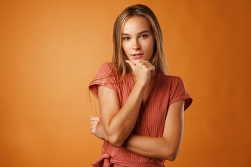 Studio portrait of beautiful young casual woman thinking