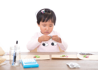 Cute Chinese little girl playing as a doctor preparing medicine