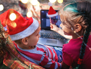 New normal online Christmas celebration. Kids celebrating with family via video chat