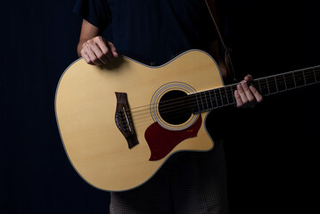 Fototapeta premium Musician at night, Player with an acoustic guitar in the dark, With side lighting.