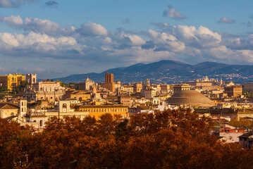 Autumn and foliage in Rome. The city historic center ancient skyline with the famous and iconic Pantheon dome rises above beautiful autumnal leaves