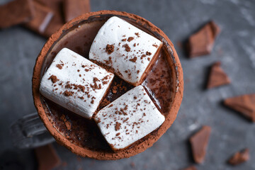 Hot chocolate and marshmallows. Cocoa in a glass goblet, cup. Dark background. Closeup.