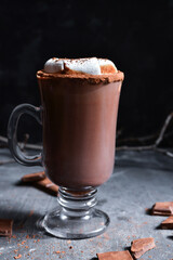 Hot chocolate and marshmallows. Cocoa in a glass goblet, cup. Dark background. Horizontal view