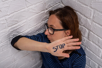 The woman shows the inscription STOP on her palm.