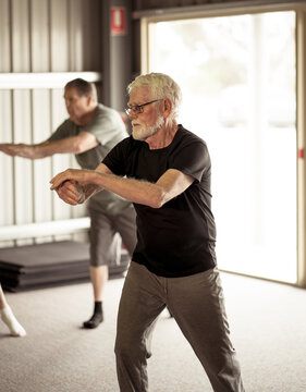 Group Of Elderly Senior People Practicing Tai Chi Class In Age Care Gym Facilities.