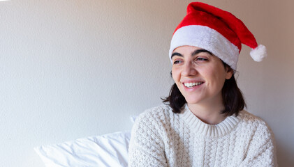 woman indoor portrait. Young beautiful with a claus hat. woman in warm knitted clothes at home. fashion. Autumn, winter