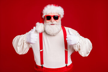 Fototapeta na wymiar Close-up portrait of his he nice handsome cheerful cheery glad bearded Santa showing two double thumbup advice cool advert ad isolated bright vivid shine vibrant red color background