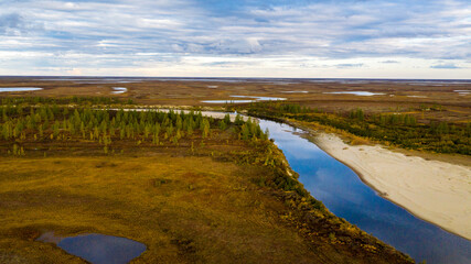 Landscape of the forest-tundra in autumn and the sandy river bank, bird's eye view.Arctic Circle, tunda. Beautiful landscape of  tundra from a helicopter.