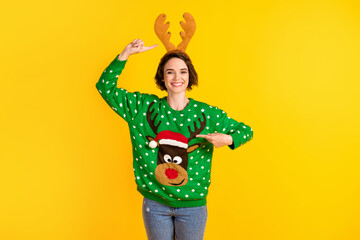 Photo positive cheerful girl point index finger deer decor sweater headband ready x-mas christmas noel theme party event wear denim jeans isolated bright shine color background