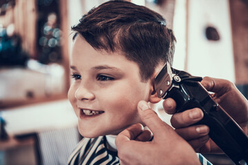 Master cuts a little boy in a barbershop. 