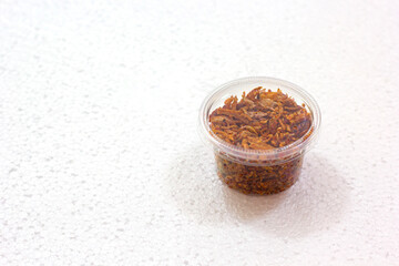 Pork Crackling Chilli Paste or Numphik is Thai food in the plastic can on white foam