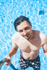 Young handsome man posing near a pool