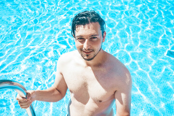 Young handsome man posing near a pool