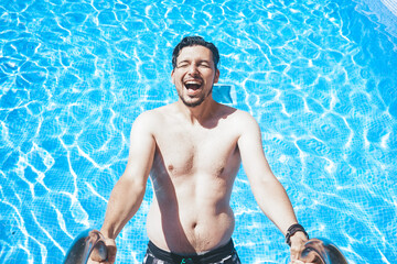 Young handsome man posing near a pool