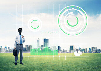 Camera headed man standing on green grass against modern cityscape