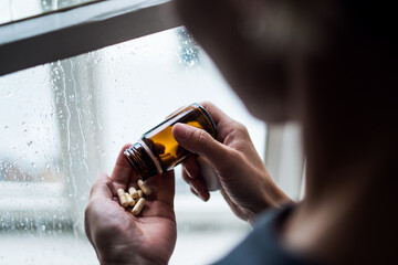 Depressed woman indoors at home, mental health and drugs addiction concept.