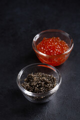 Black and red caviar in glass bowls on black  background. Sturgeon and salmon caviar.