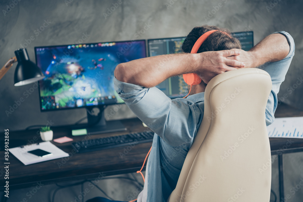 Poster rear back behind view of his he nice focused guy geek playing web network game remote freelance rest