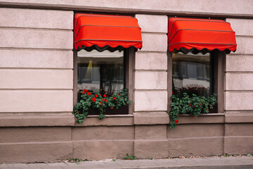 Red exterior window awnings outside the store