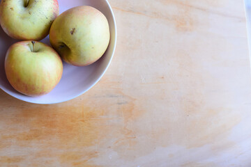 Fresh Apples in the Plate on Wooden Table