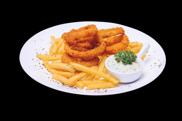 Onion rings and fries with tartar sauce served on a white plate on a dark table, top view.
