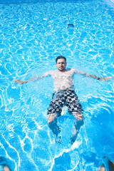 Young man enyoing the day at the swimming pool