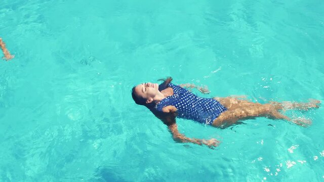 man and a woman swim in the pool