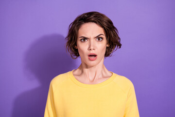 Portrait of shocked disappointed girl stare in camera wear bright sweatshirt isolated over violet color background