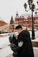 Young lovers enjoy time together on the street in the city, on the winter holidays, romance.