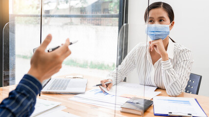 business team brainstorm they are working hard by looking through the plastic protective wall, concept of social distancing to prevent the spread of coronavirus COVID-19