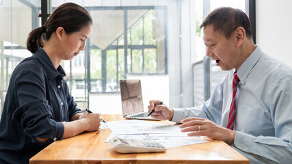 Mature boss senior Asian businessman leadership working together colleagues discuss information over a report document  in a meeting in office.