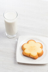 Milk on the table and cookies with smiling faces on them