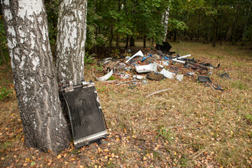 Abandoned corroded car radiator in the middle of the forest in autumn, Illegal garbage dump