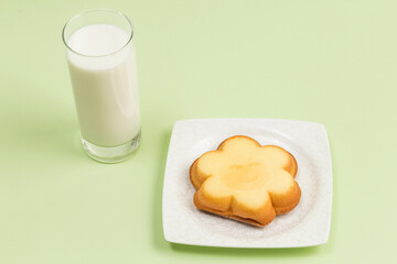 Milk on the table and cookies with smiling faces on them