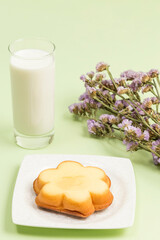 Milk on the table and cookies with smiling faces on them