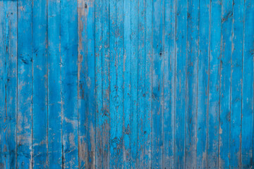 Fototapeta na wymiar Blue fence made of planks with knots. Background. Copy space.