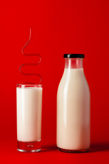 Glass bottle and glass cup with milk front view