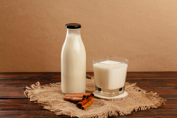 Glass bottle and glass cup with milk front view