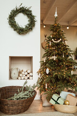Beautiful Christmas tree, wreath frame, gift boxes in cozy comfortable living room. Festive Christmas / New Year holidays celebration decorations in modern interior design.