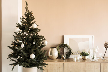 Fototapeta premium Beautiful Christmas tree with toys, baubles and homemade paper gift boxes. Living room decorated for Christmas / New Year celebration. Modern interior design concept.