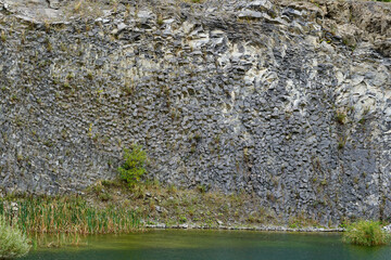 Lake in an ancient quarry with various types of rocks