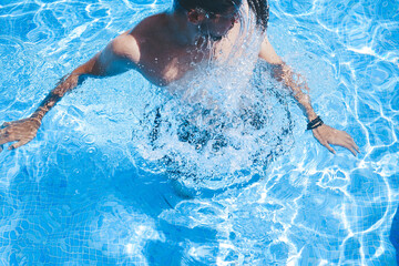 Young man enyoing the day at the swimming pool