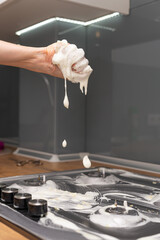 Woman's hand cleaning gas stove