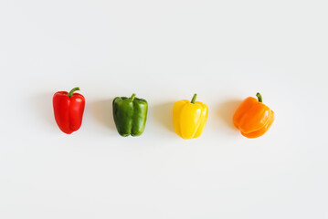 Red, green, yellow and orange bell pepper on white background, top view. flat lay. Capsicum mix