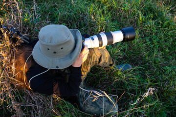 Obraz premium photographer taking pictures of wildlife with a telephoto lens