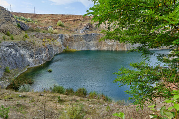 Fototapeta na wymiar Lake in an ancient quarry with various types of rocks