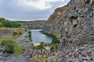 Fototapeta na wymiar Lake in an ancient quarry with various types of rocks