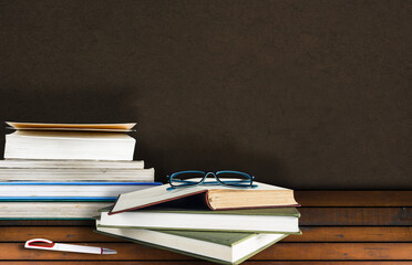 glasses and books on wooden desk
